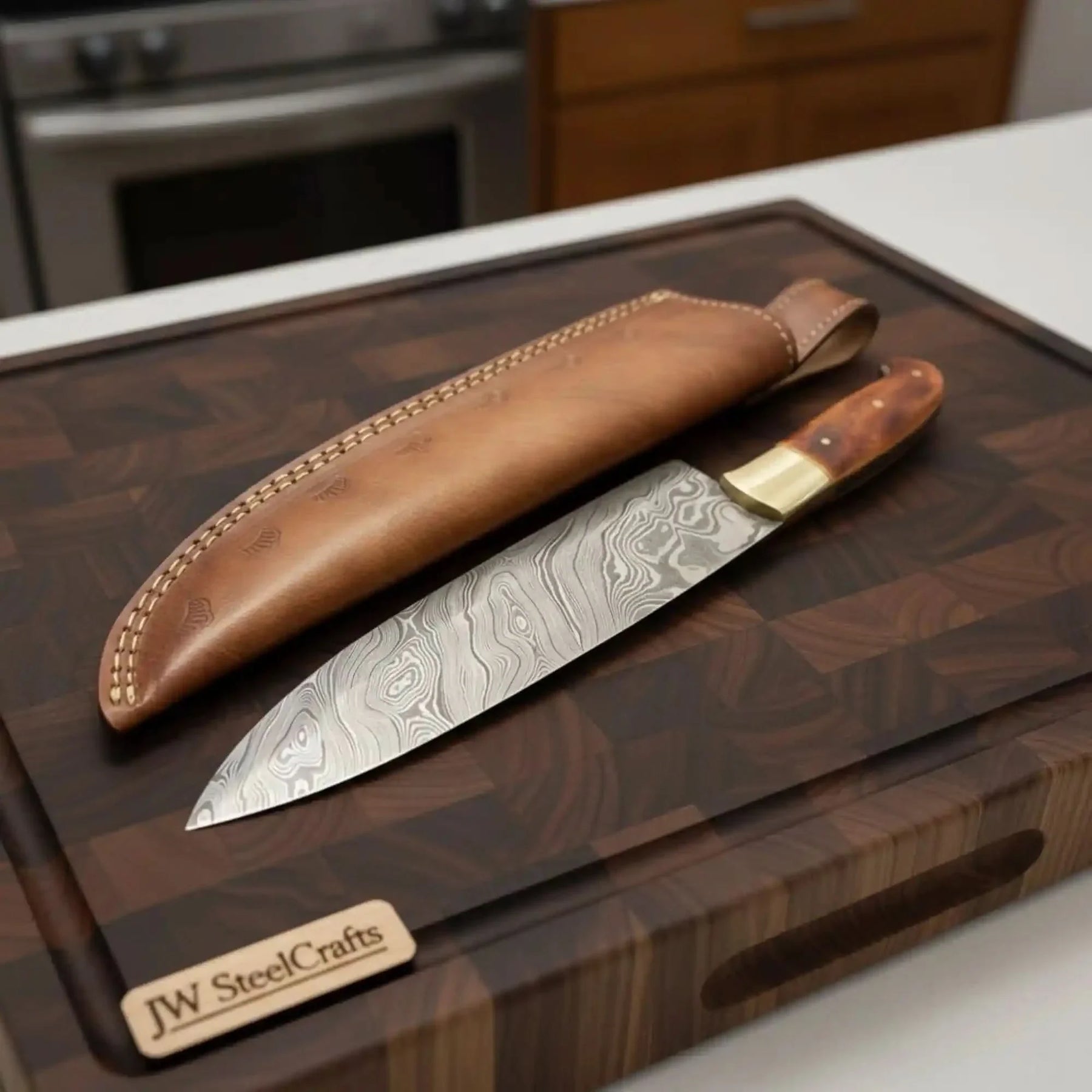 Handmade damascus steel knife with leather handle on dark surface