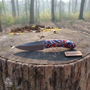 Handmade damascus steel knife with resin handle on dark surface