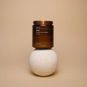 Brown glass soy candle labeled "Ritual" by gold + ivy