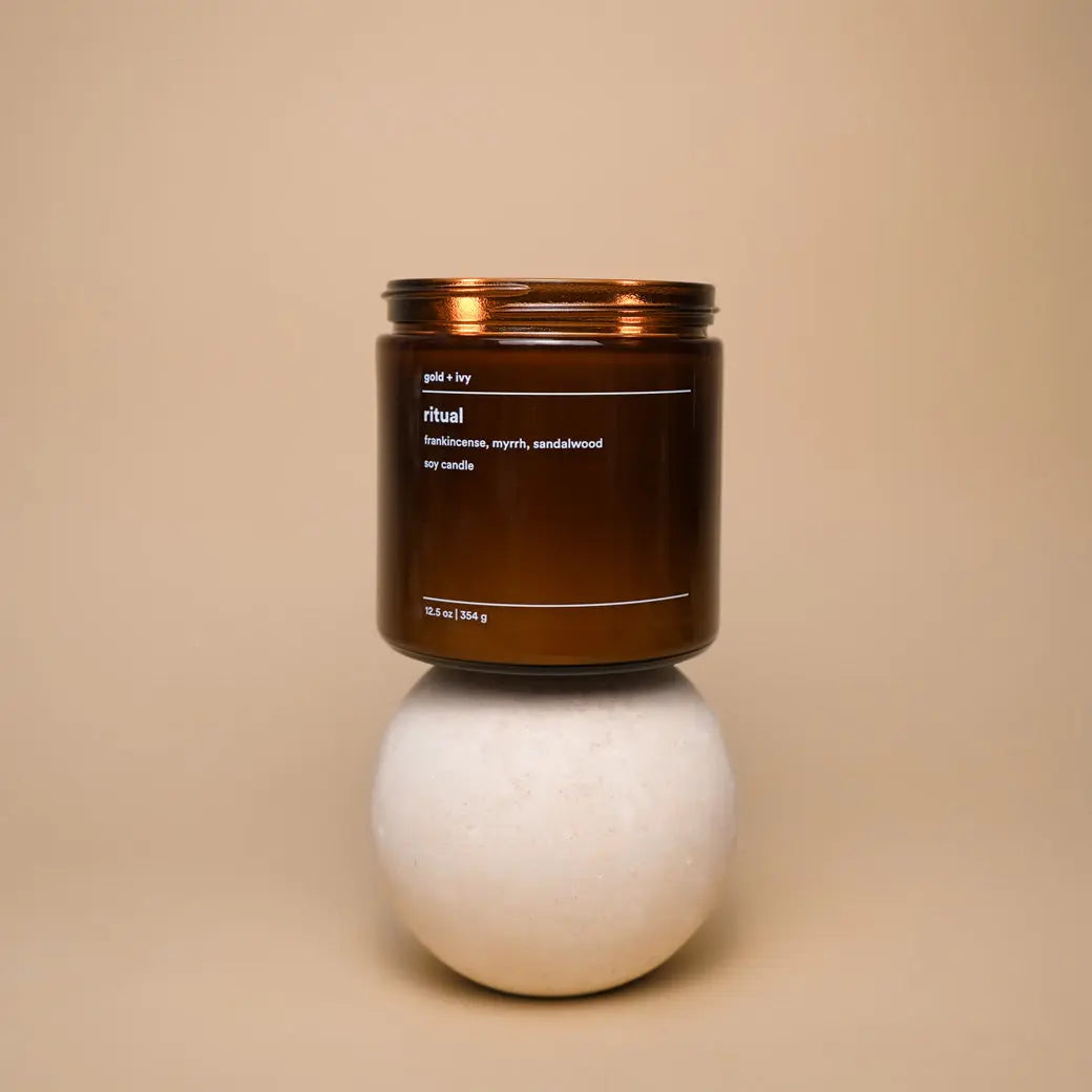Amber glass soy candle with "Ritual" label, featuring frankincense, myrrh, and sandalwood scent.