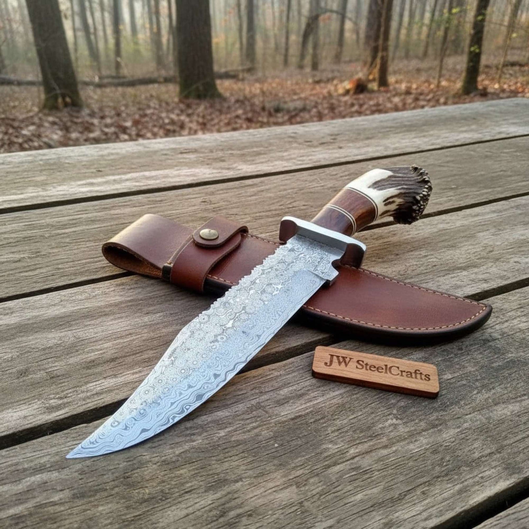 Handmade damascus steel knife with premium handle on dark surface