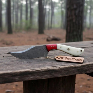 Handmade damascus steel knife with bone handle on dark surface