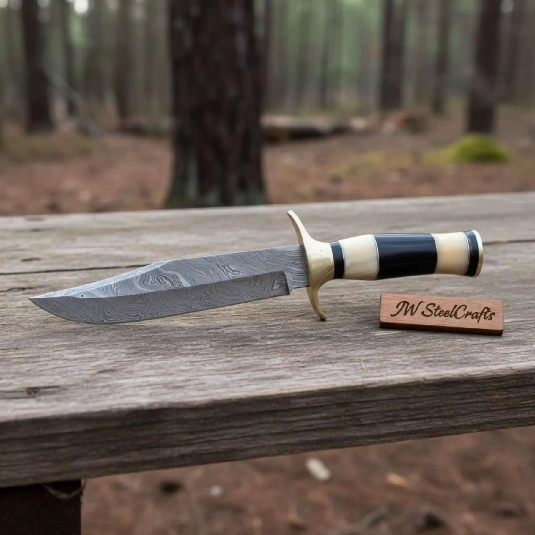 Handmade damascus steel knife with premium handle on dark surface