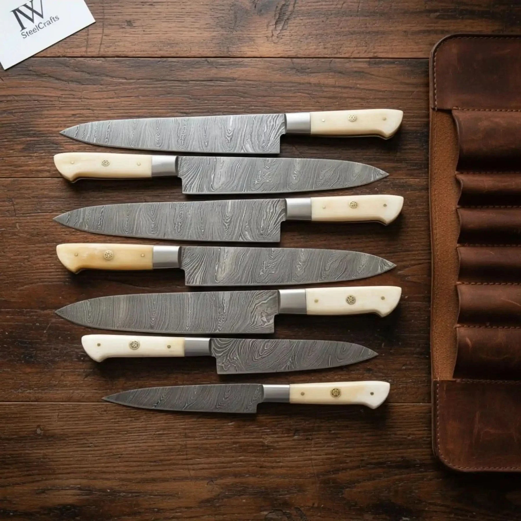 Handmade damascus steel knife with bone handle on dark surface