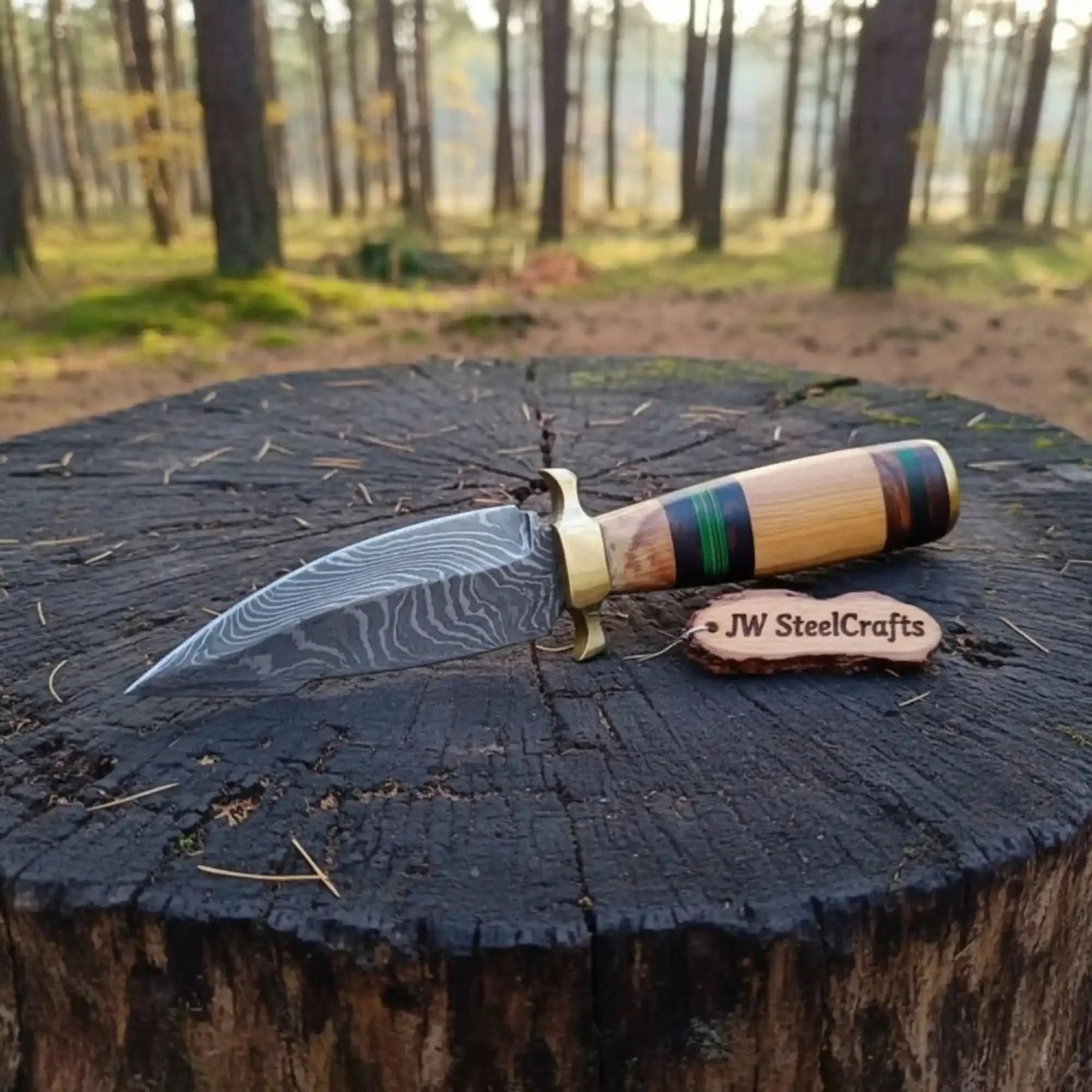 Handmade damascus steel knife with wood handle on dark surface