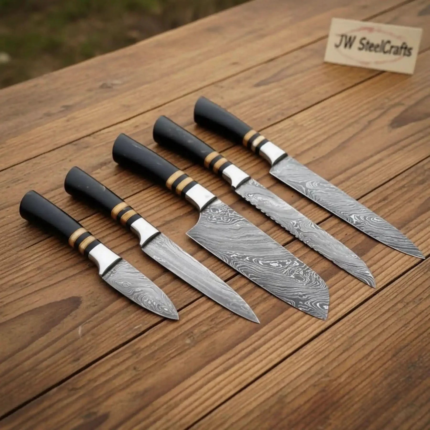 Handmade damascus steel knife with premium handle on dark surface