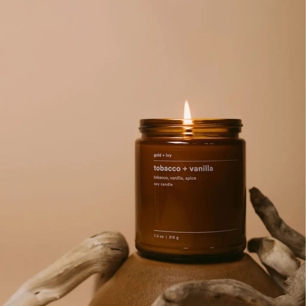 Amber glass soy candle with tobacco and vanilla scent lit