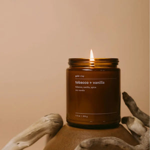 Amber glass soy candle with tobacco and vanilla scent lit
