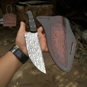 Handmade damascus steel knife with walnut handle on dark surface