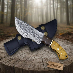 Handmade damascus steel knife with wood handle on dark surface