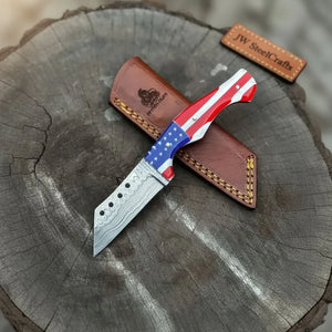 Handmade damascus steel knife with resin handle on dark surface