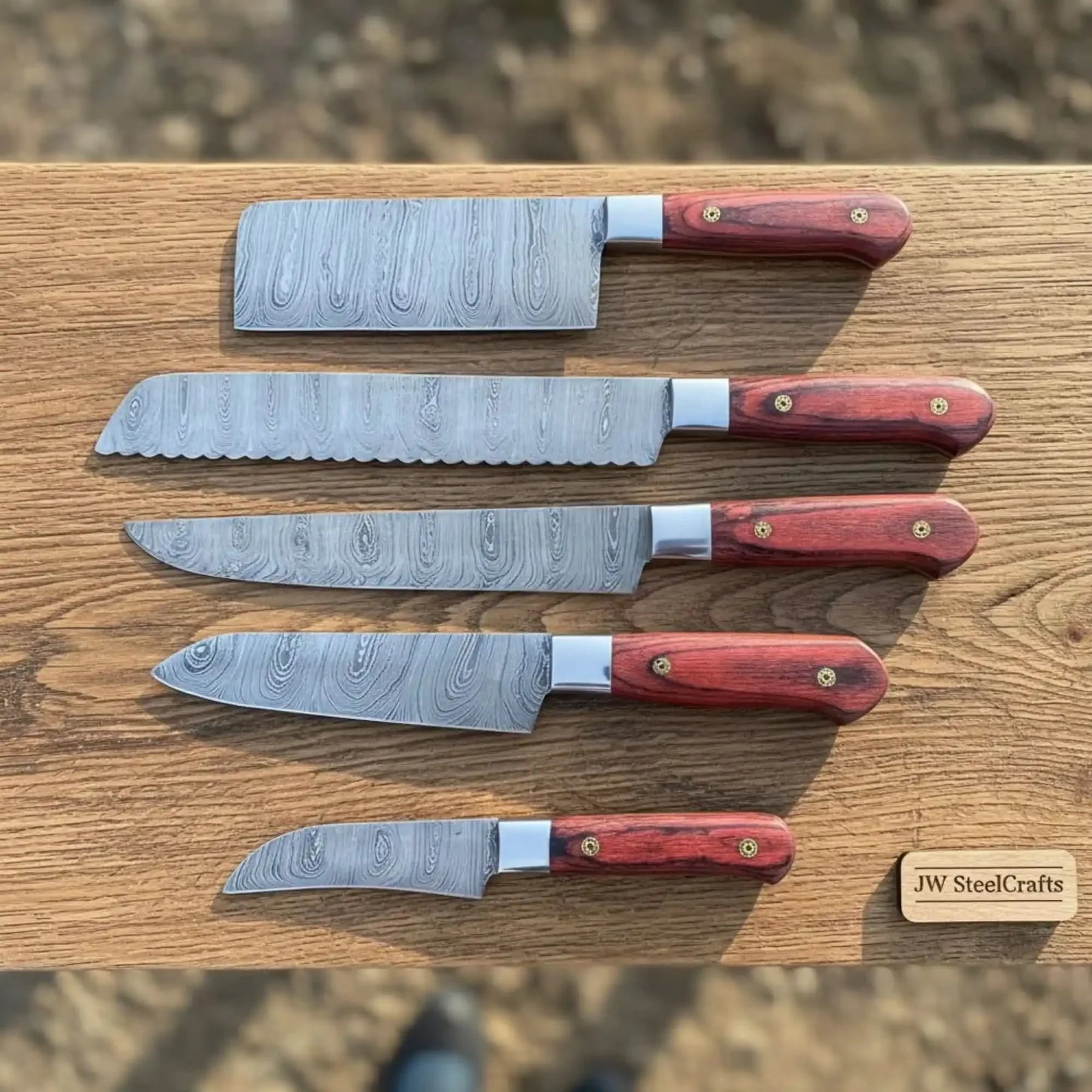 Handmade damascus steel knife with wood handle on dark surface