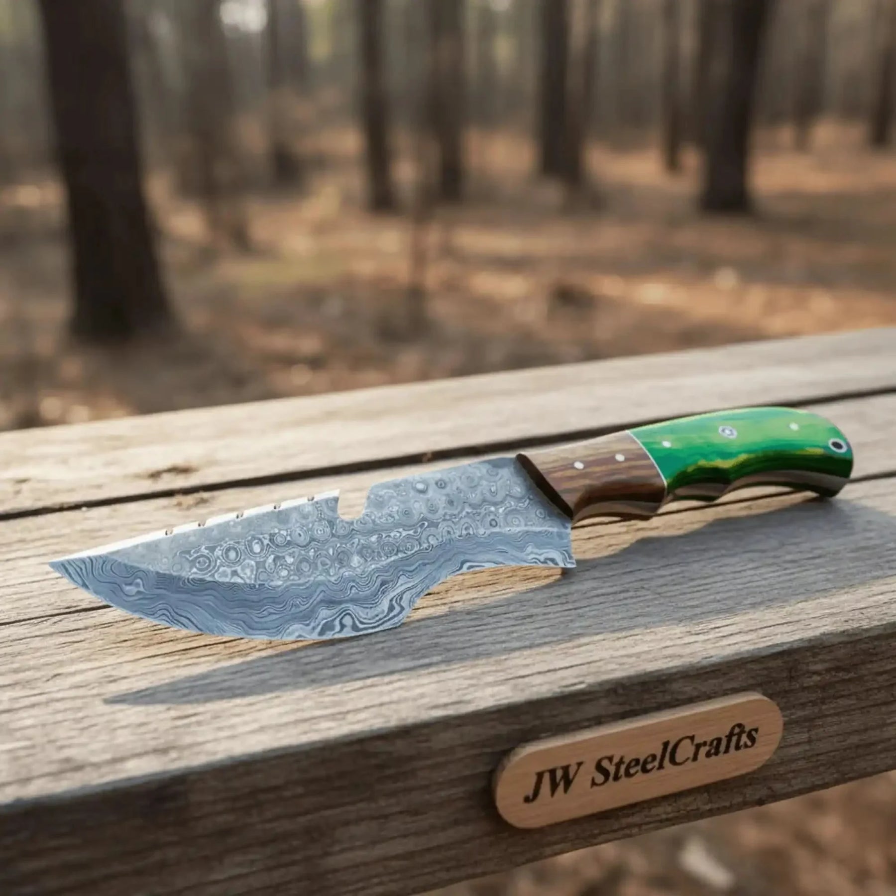 Handmade damascus steel knife with wood handle on dark surface