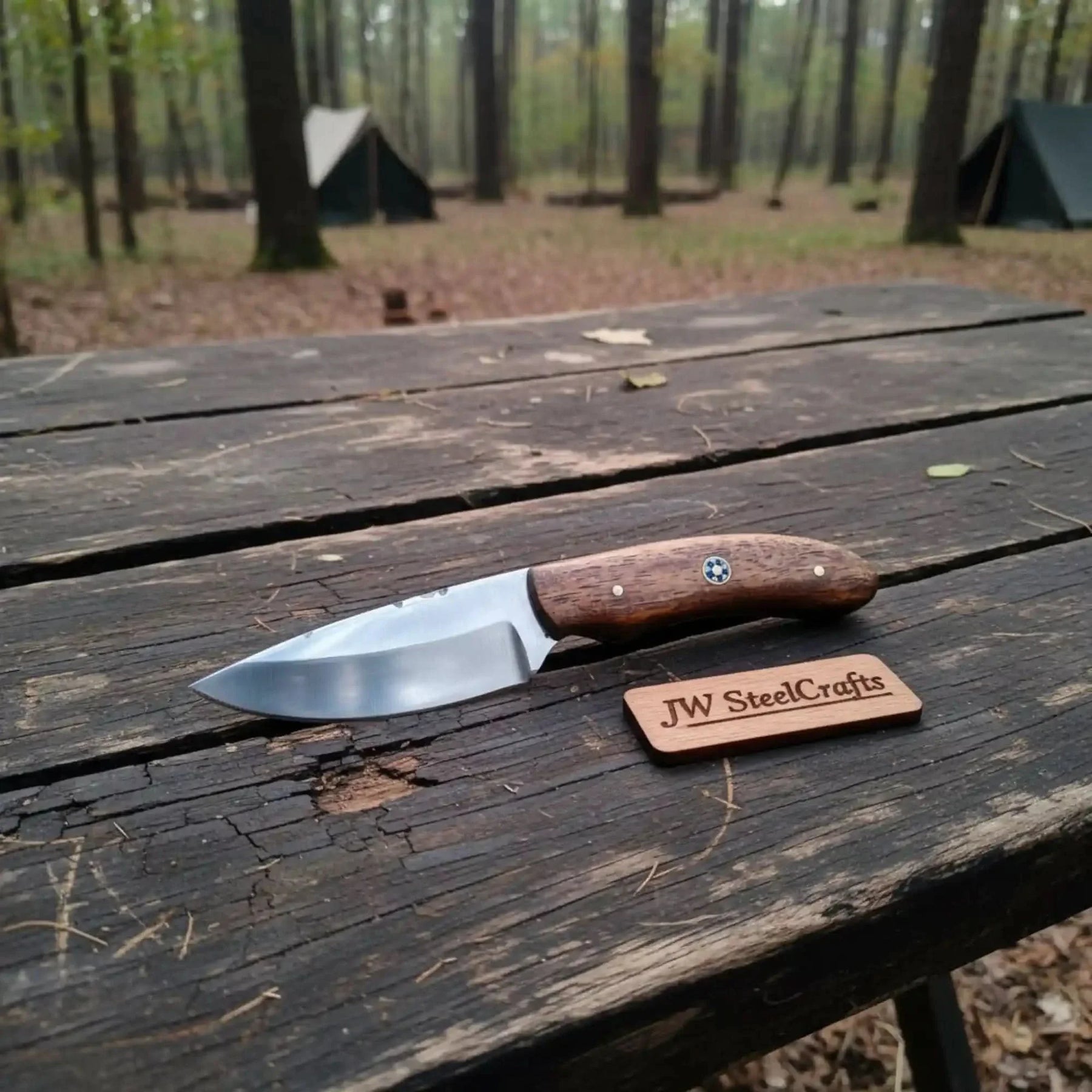 Handmade damascus steel knife with wood handle on dark surface