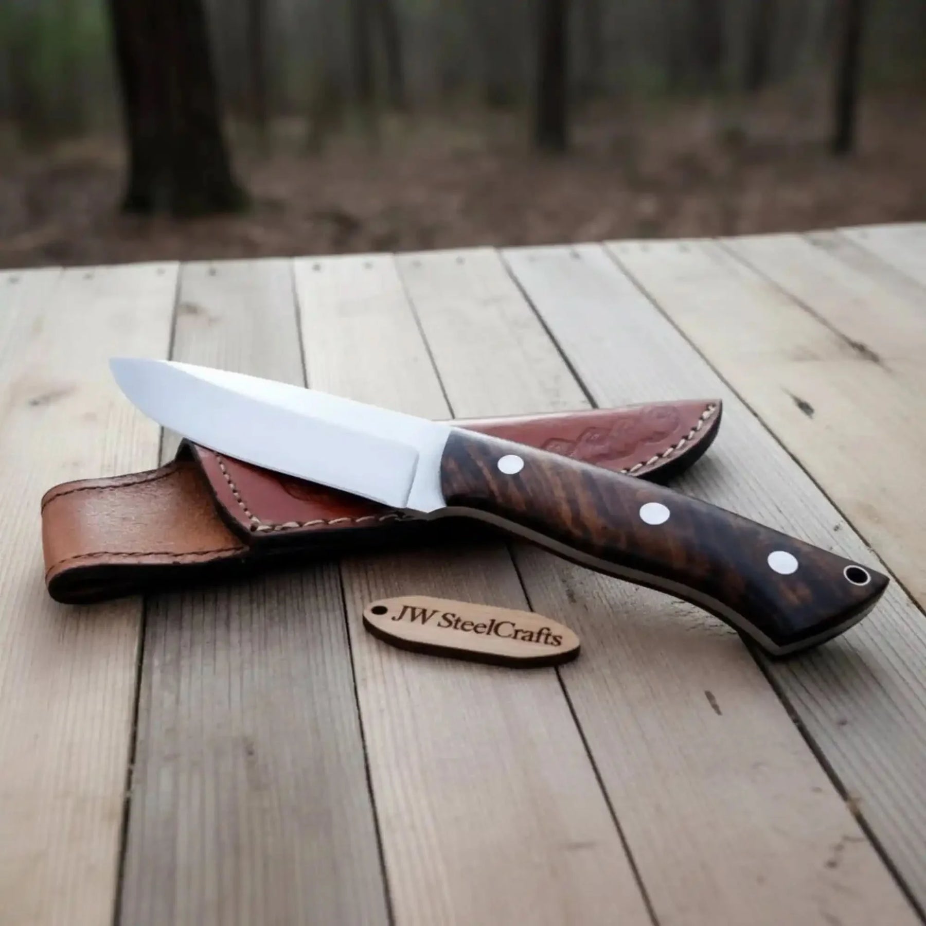 Handmade stainless steel steel knife with wood handle on dark surface