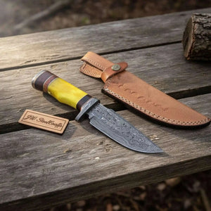 Handmade damascus steel knife with wood handle on dark surface
